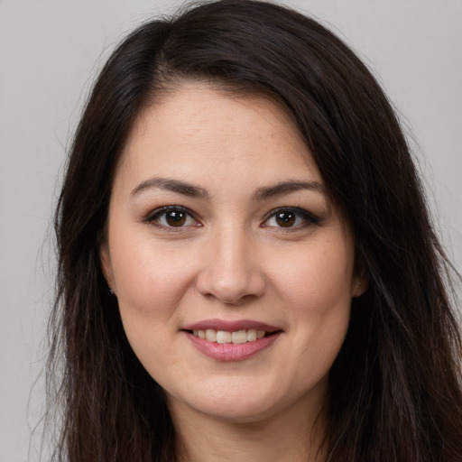 Joyful white young-adult female with long  brown hair and brown eyes