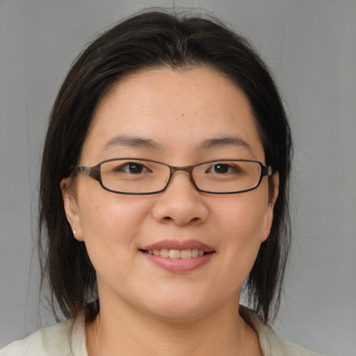 Joyful asian young-adult female with medium  brown hair and brown eyes