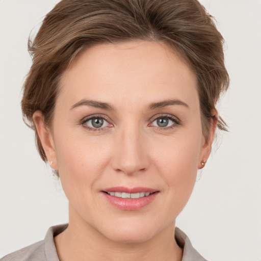 Joyful white young-adult female with medium  brown hair and grey eyes