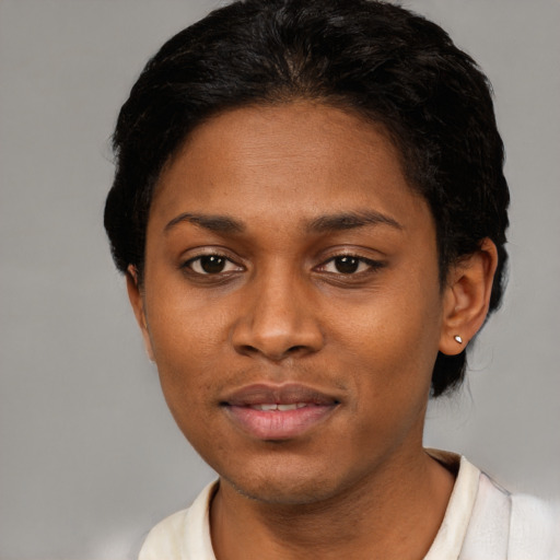 Joyful black young-adult female with short  black hair and brown eyes
