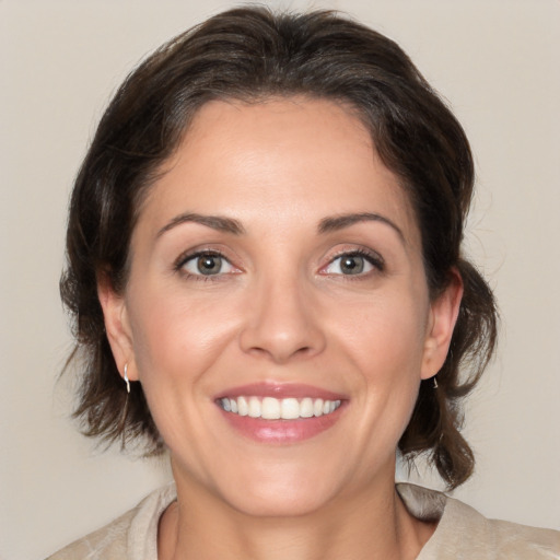 Joyful white adult female with medium  brown hair and brown eyes