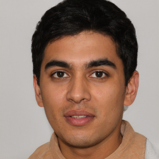 Joyful latino young-adult male with short  black hair and brown eyes