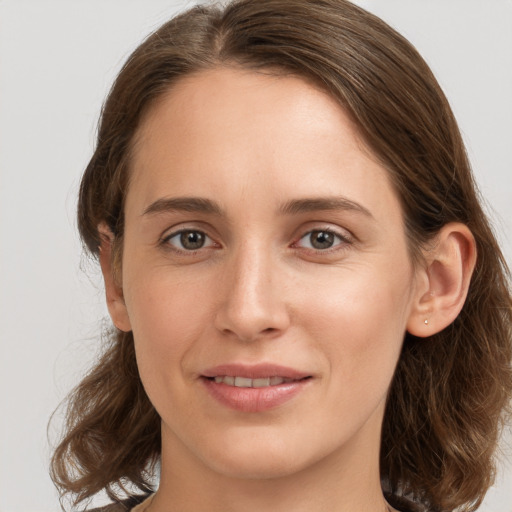 Joyful white young-adult female with medium  brown hair and grey eyes