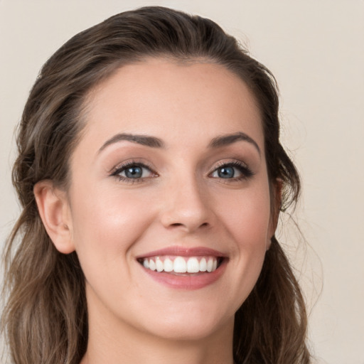 Joyful white young-adult female with long  brown hair and grey eyes