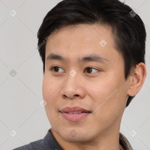 Joyful asian young-adult male with short  brown hair and brown eyes