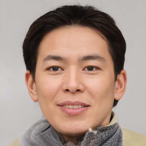 Joyful asian young-adult male with short  brown hair and brown eyes