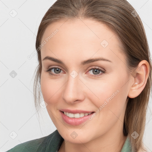 Joyful white young-adult female with medium  brown hair and grey eyes