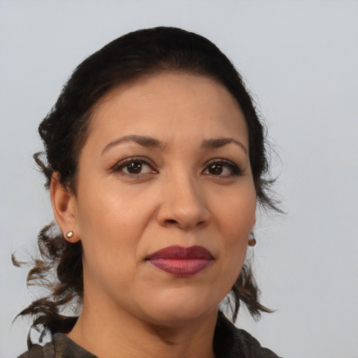 Joyful latino adult female with medium  brown hair and brown eyes
