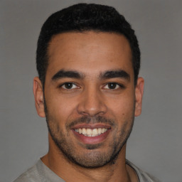 Joyful latino young-adult male with short  black hair and brown eyes