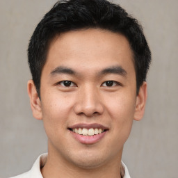 Joyful asian young-adult male with short  black hair and brown eyes