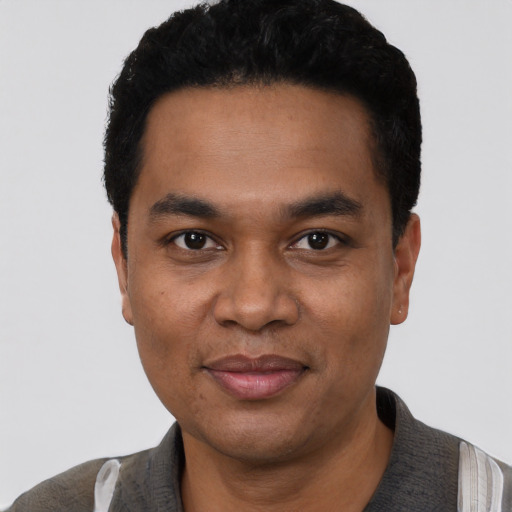 Joyful black young-adult male with short  black hair and brown eyes