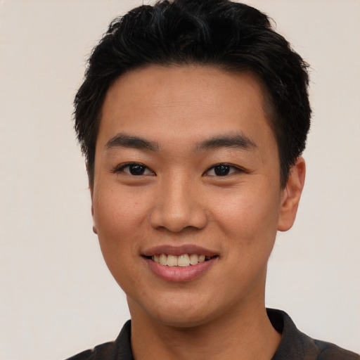 Joyful asian young-adult male with short  black hair and brown eyes