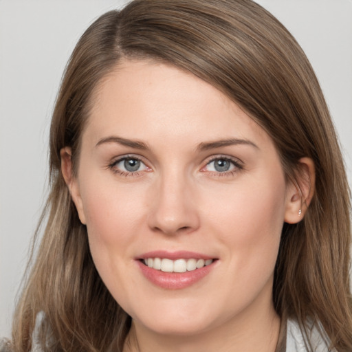 Joyful white young-adult female with long  brown hair and grey eyes