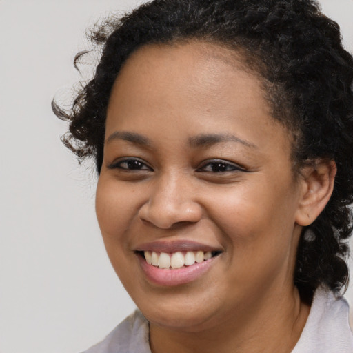 Joyful black young-adult female with medium  brown hair and brown eyes