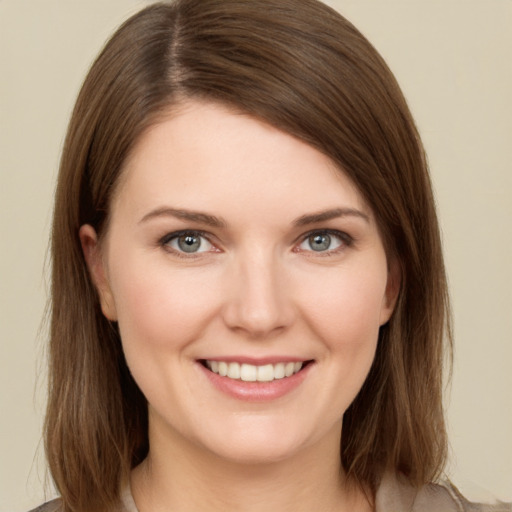 Joyful white young-adult female with medium  brown hair and grey eyes