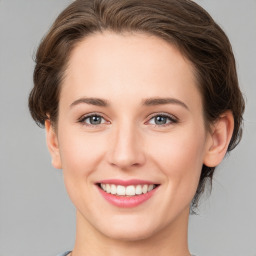 Joyful white young-adult female with medium  brown hair and green eyes