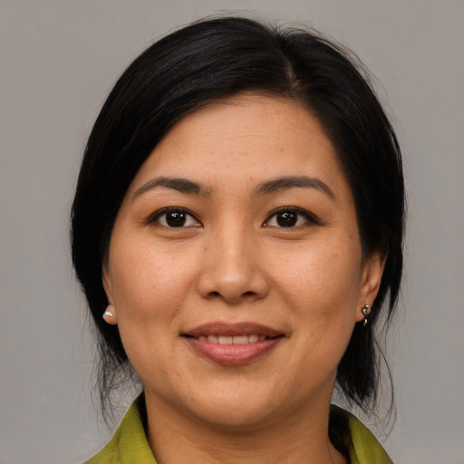 Joyful latino adult female with medium  black hair and brown eyes