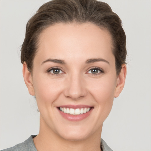 Joyful white young-adult female with short  brown hair and grey eyes