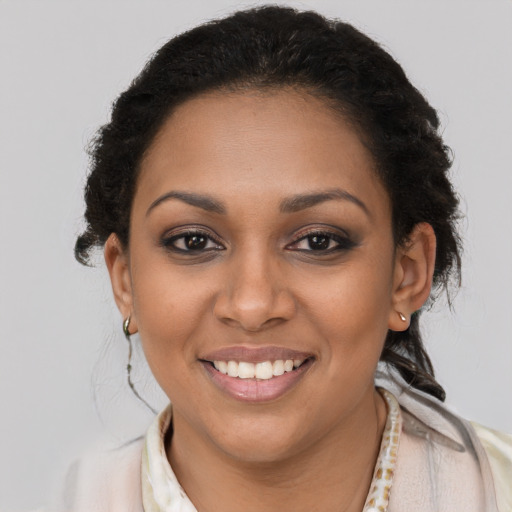 Joyful black young-adult female with long  brown hair and brown eyes