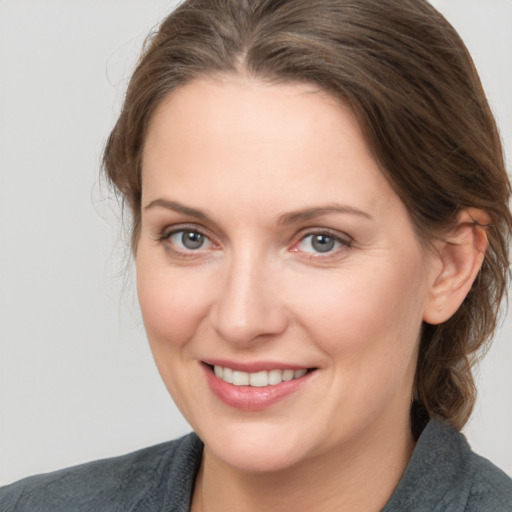 Joyful white young-adult female with medium  brown hair and grey eyes