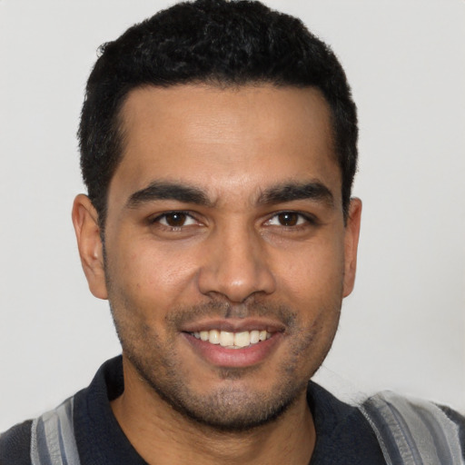 Joyful latino young-adult male with short  black hair and brown eyes