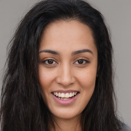 Joyful latino young-adult female with long  brown hair and brown eyes