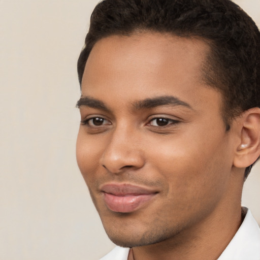 Joyful black young-adult male with short  brown hair and brown eyes