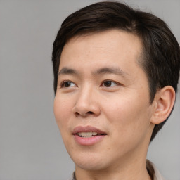 Joyful asian young-adult male with short  brown hair and brown eyes