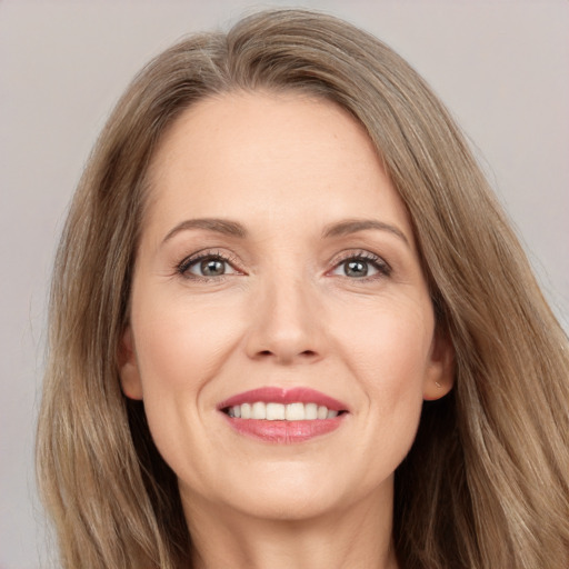 Joyful white adult female with long  brown hair and brown eyes