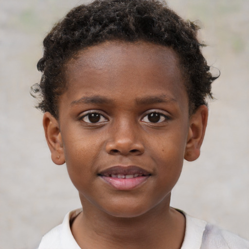 Joyful black child male with short  brown hair and brown eyes
