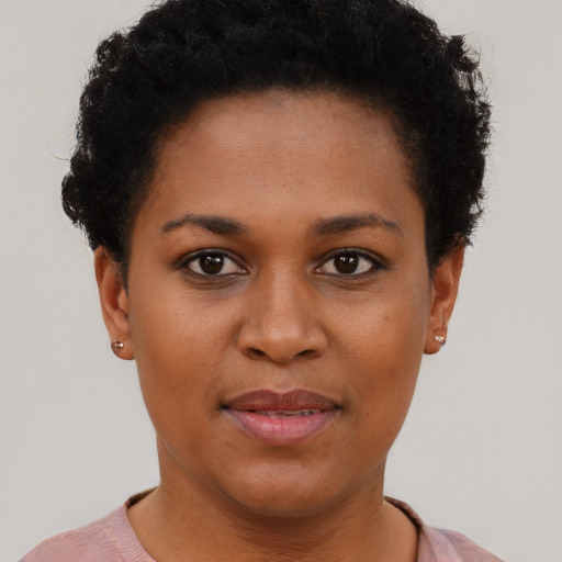 Joyful black young-adult female with short  black hair and brown eyes