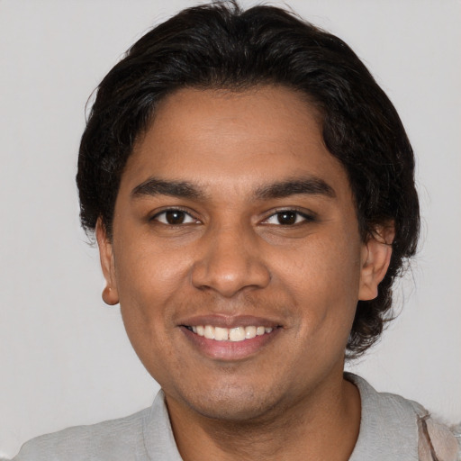 Joyful black young-adult male with short  brown hair and brown eyes