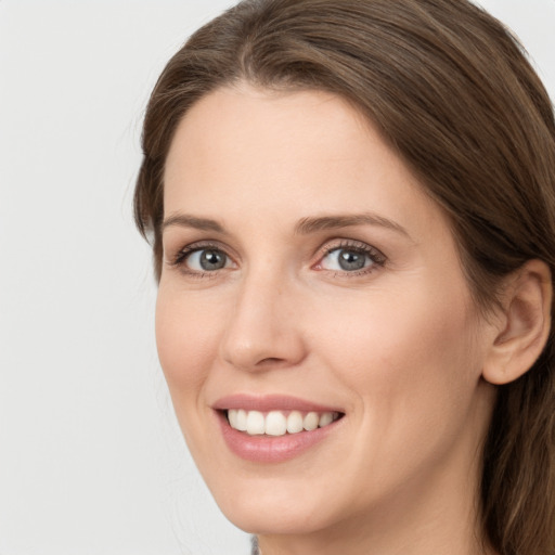 Joyful white young-adult female with long  brown hair and grey eyes