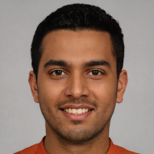 Joyful latino young-adult male with short  black hair and brown eyes