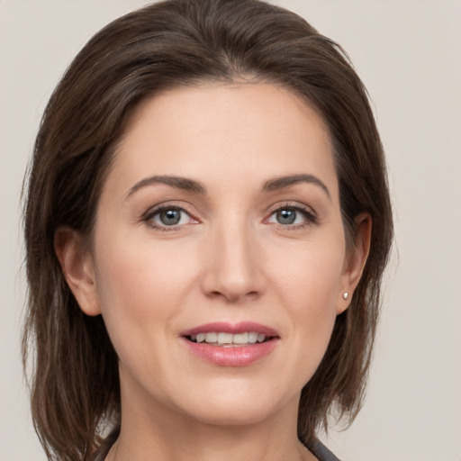 Joyful white young-adult female with medium  brown hair and grey eyes