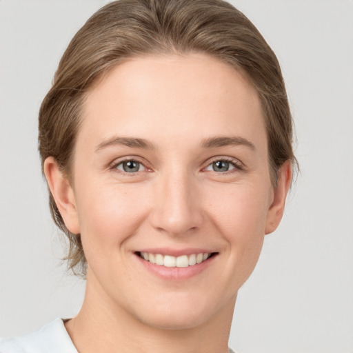 Joyful white young-adult female with medium  brown hair and grey eyes