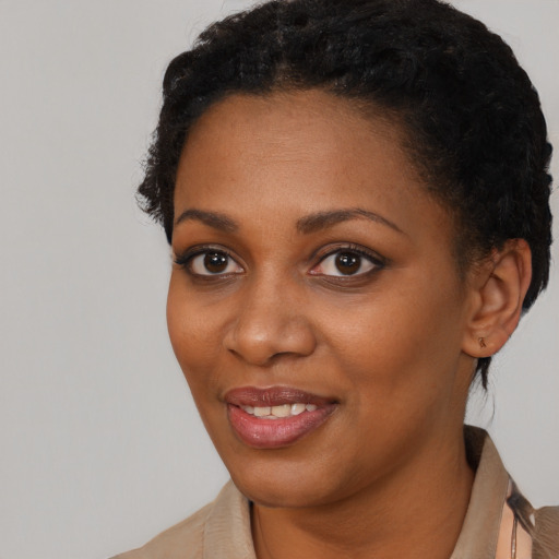 Joyful black young-adult female with short  brown hair and brown eyes