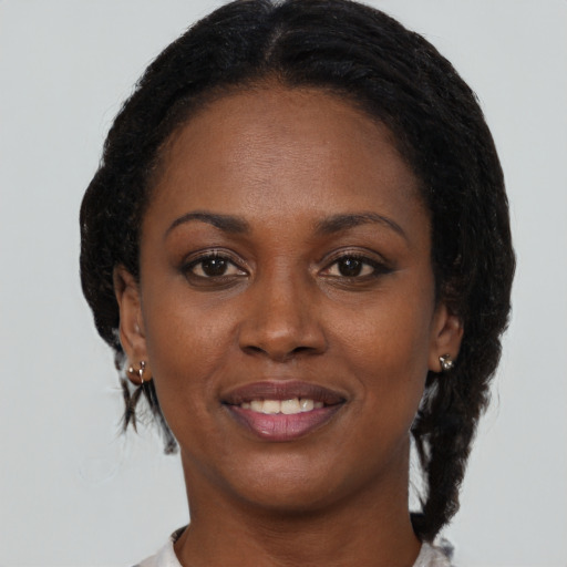 Joyful black young-adult female with medium  brown hair and brown eyes