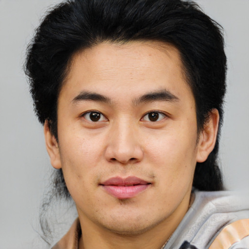 Joyful asian young-adult male with short  brown hair and brown eyes