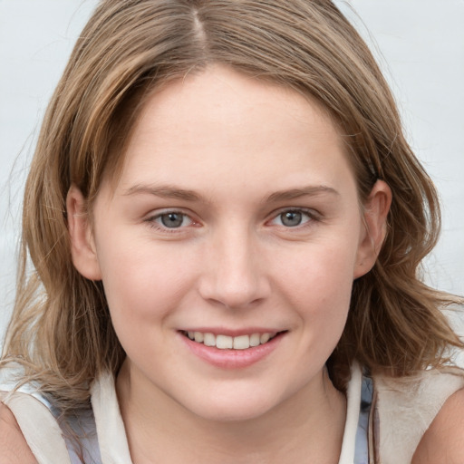 Joyful white young-adult female with medium  brown hair and blue eyes