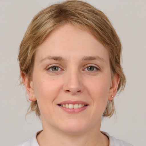 Joyful white young-adult female with medium  brown hair and blue eyes