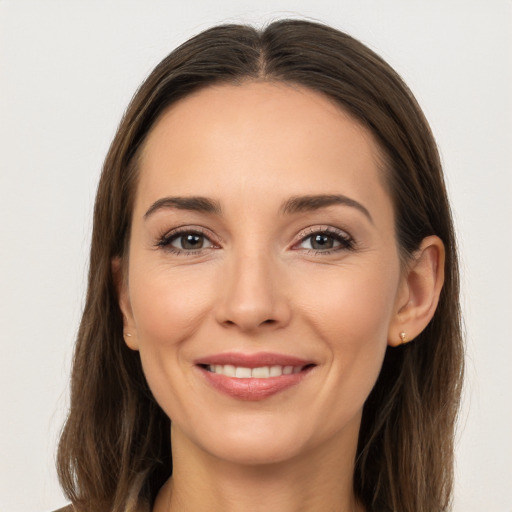 Joyful white young-adult female with long  brown hair and brown eyes