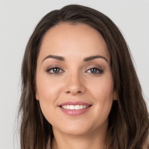 Joyful white young-adult female with long  brown hair and grey eyes