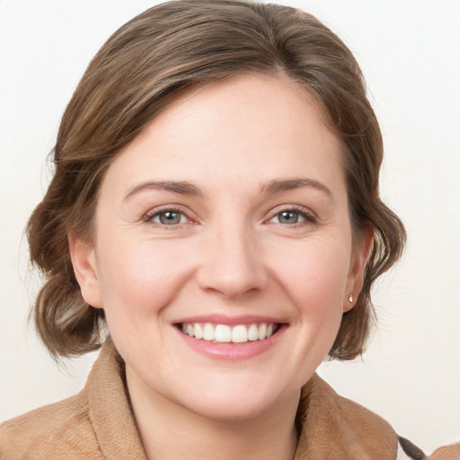 Joyful white young-adult female with medium  brown hair and blue eyes