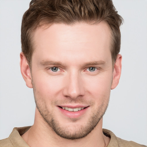 Joyful white young-adult male with short  brown hair and grey eyes