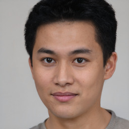 Joyful asian young-adult male with short  black hair and brown eyes