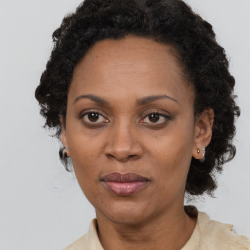 Joyful black adult female with short  black hair and brown eyes
