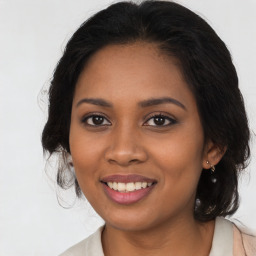 Joyful black young-adult female with long  brown hair and brown eyes