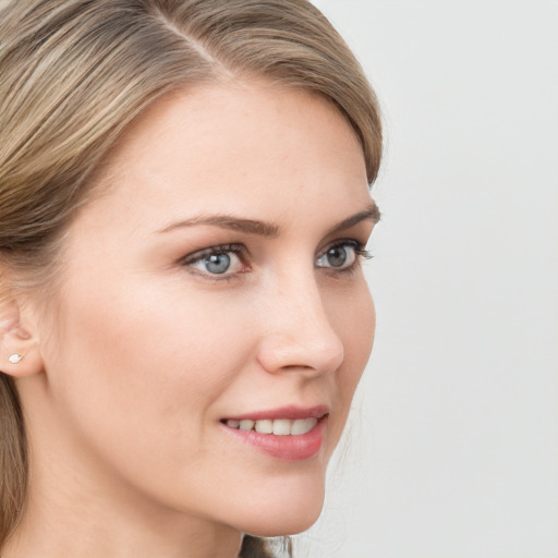 Joyful white young-adult female with long  brown hair and blue eyes