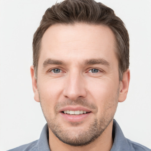 Joyful white young-adult male with short  brown hair and grey eyes